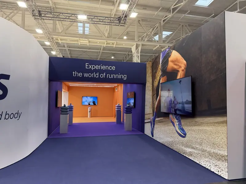 Ingresso dello stand ASICS con la scritta "Experience the world of running"