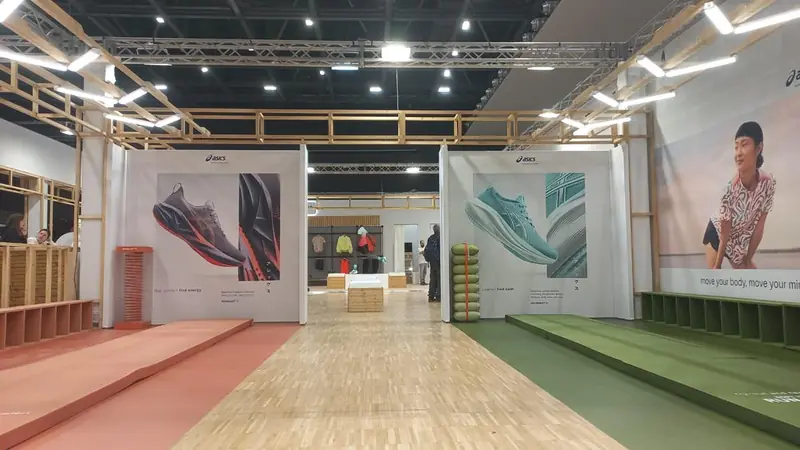Stand ASICS con pannelli grafici e pavimento in legno colorato