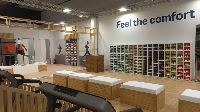 Area ASICS "Feel the comfort" con tapis roulant e parete di scarpe