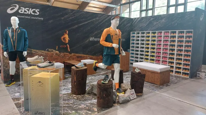Stand con manichini e scarpe su tronchi, con parete di scarpe