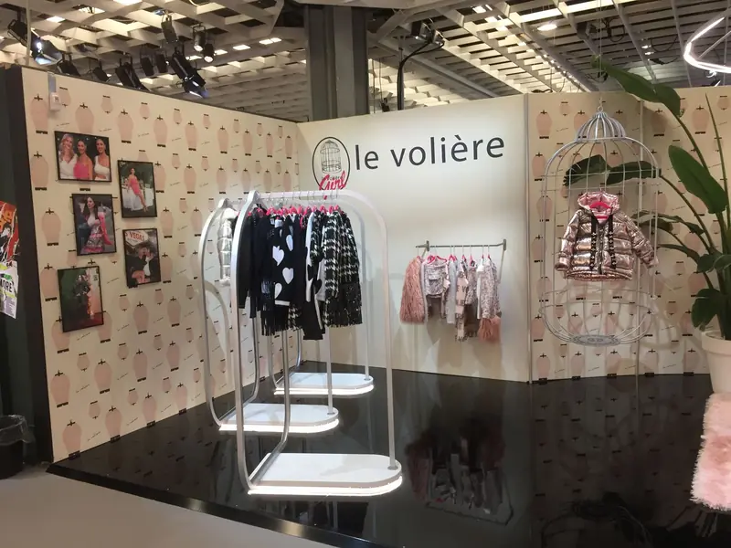 Stand con abiti per bambini e gabbia decorativa