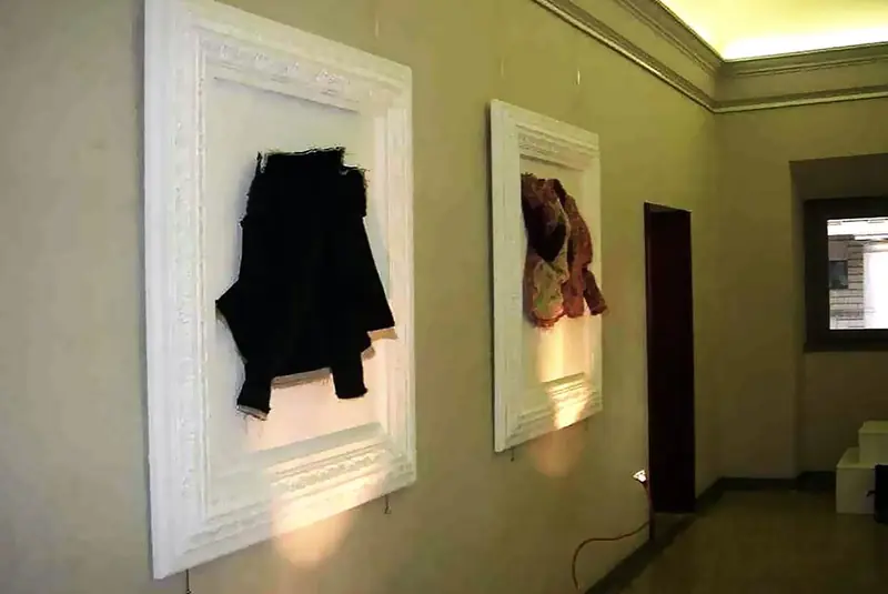 Cornici bianche a parete con capi di abbigliamento