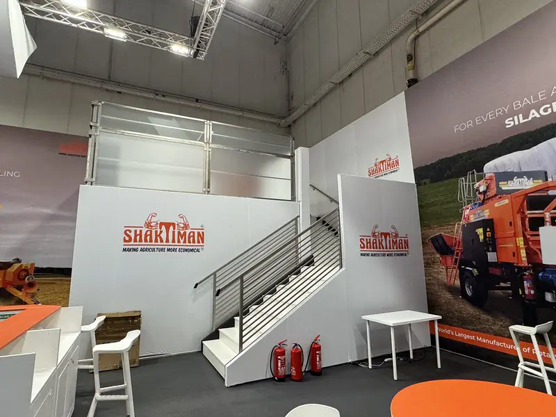 Interno dello stand Shaktiman con scala e grafiche di trattori