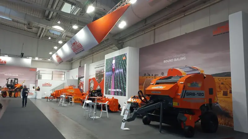 Stand arancione con rotopresse esposte in padiglione
