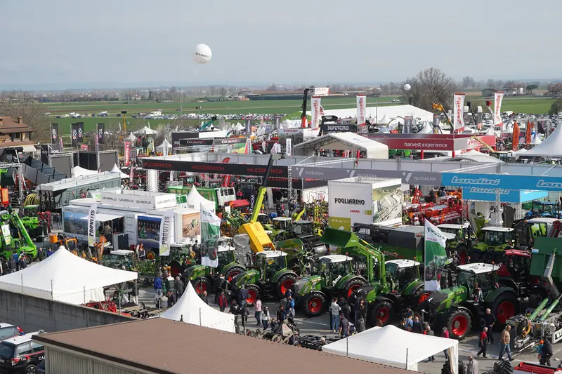 Veduta dall'alto di una fiera agricola all'aperto con trattori e tendoni