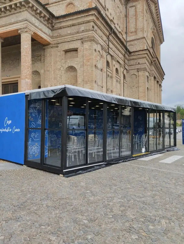 Struttura vetrata modulare davanti a un edificio storico