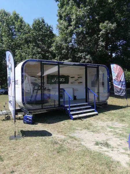 Rimorchio-showroom vetrato con scalini in un parco