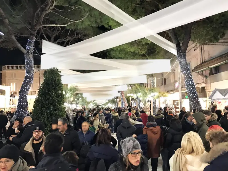 Passaggio pedonale affollato con drappi bianchi sospesi