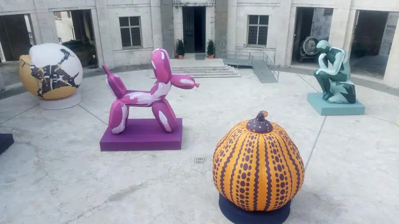 Cane palloncino rosa, zucca a pois e statue gonfiabili in un cortile