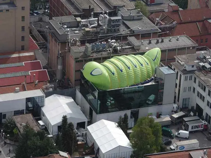 Bruco gonfiabile verde su un tetto, visto dall'alto