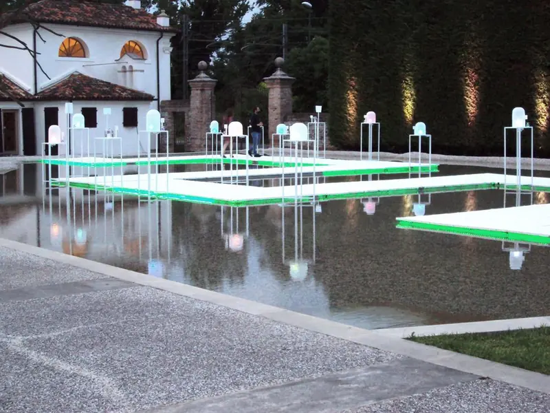 Vasca d'acqua con passerelle verdi luminose in un giardino