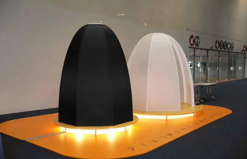 Due cupole, una nera e una bianca, su una base luminosa