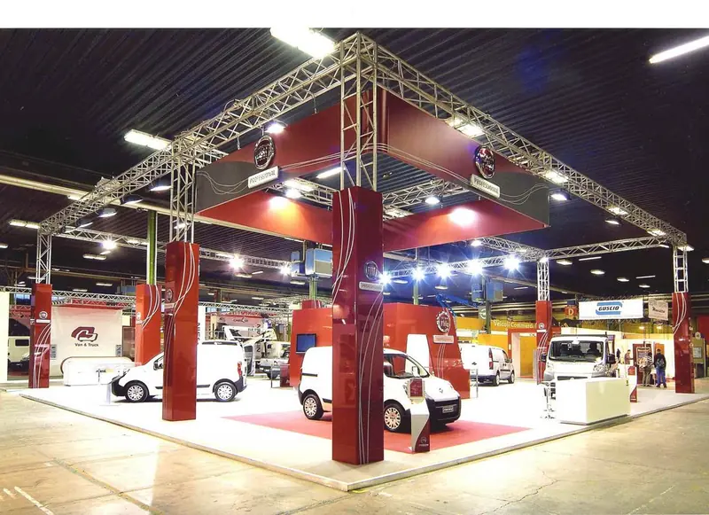 Stand con struttura in traliccio rossa e veicoli commerciali