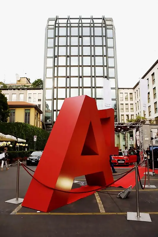 Grande lettera A rossa in una piazza davanti a un edificio