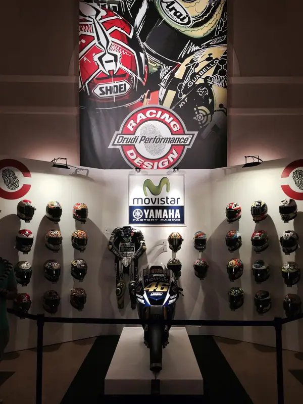 Esposizione di caschi con moto Yamaha e bandiera Shoei