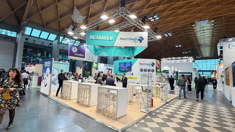 Stand con banchi alti e pavimento a scacchi in una fiera