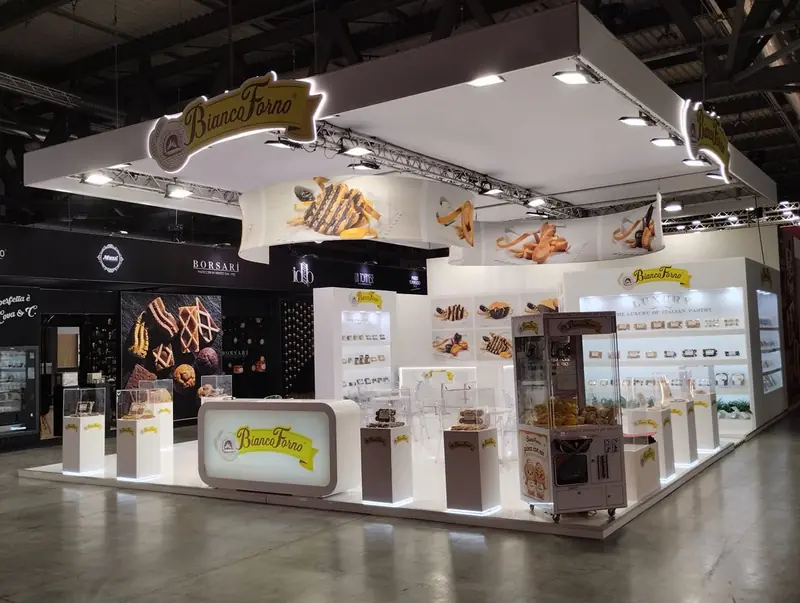 Stand bianco con vetrine di prodotti da forno e banco