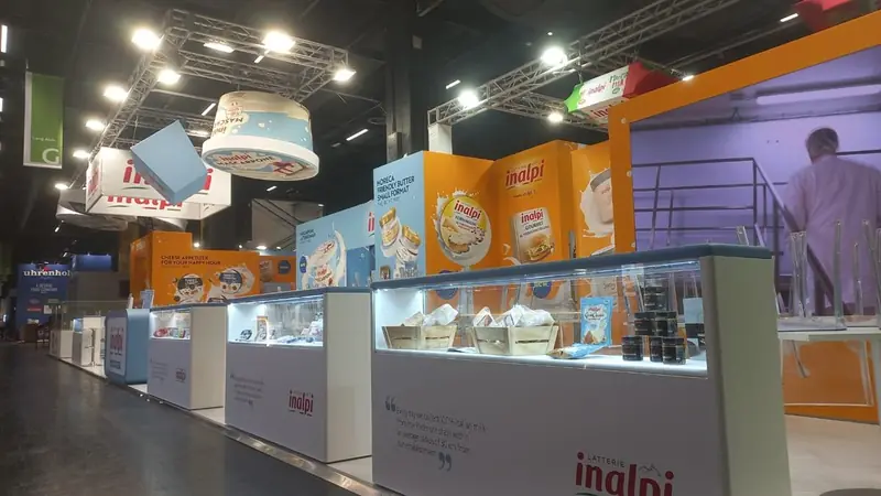 Stand Inalpi con banco vetrina e grafiche arancioni