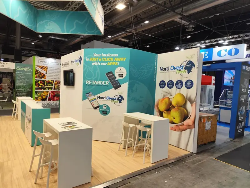 Stand Nord Ovest con tavoli alti e grafica di pere