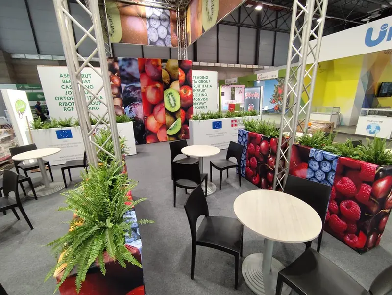 Stand con pareti grafiche di frutta e piante in vaso