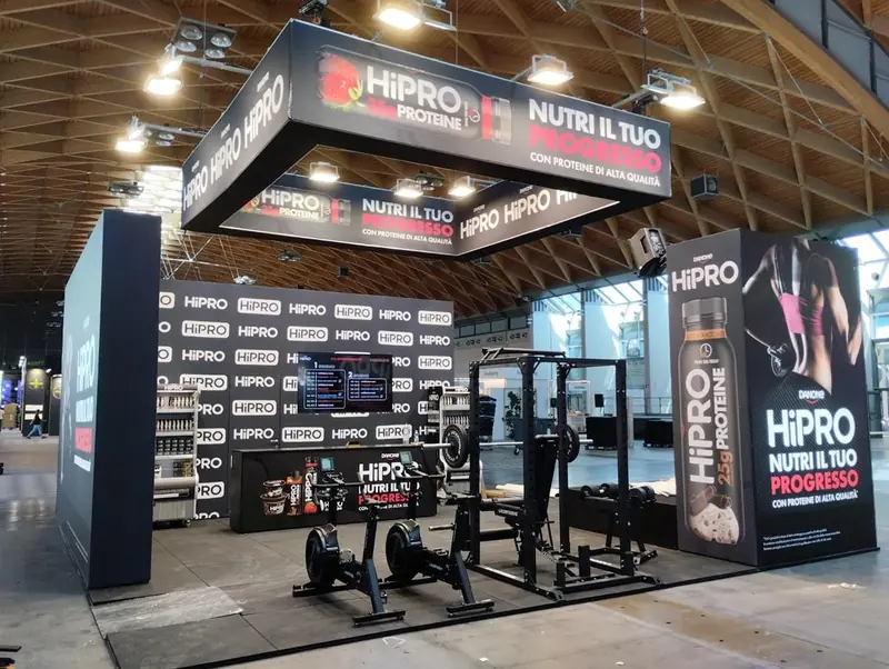 Stand Hipro con insegna nera, grafiche e attrezzi da palestra