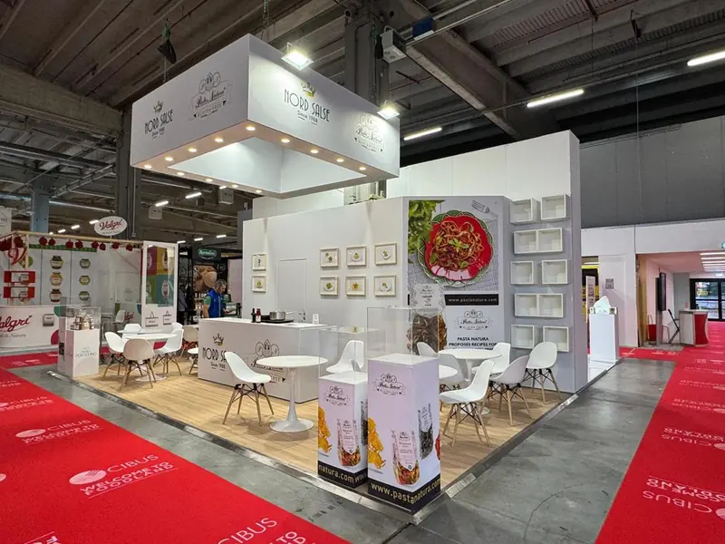 Stand bianco con scaffali, tavolini e moquette rossa