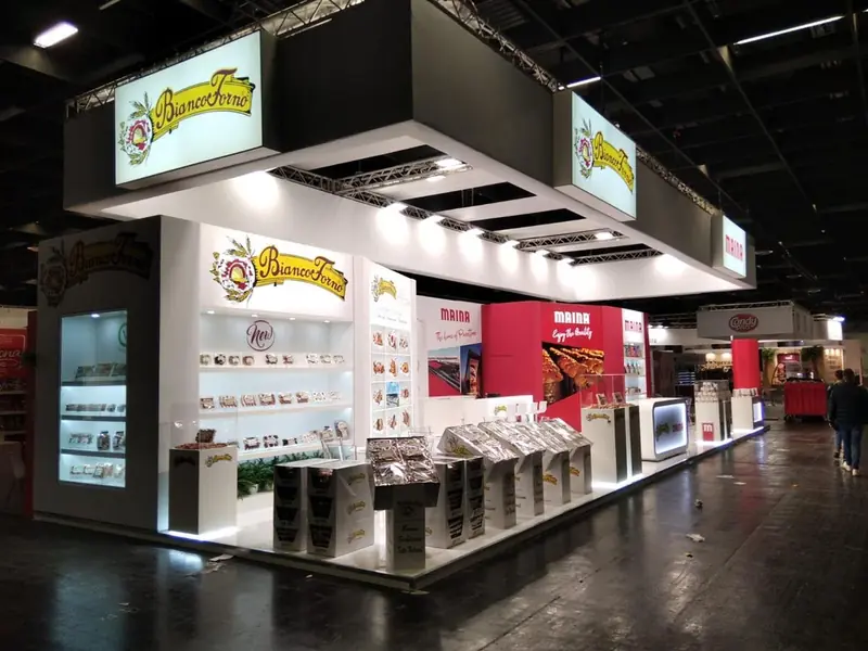 Stand con espositori di prodotti da forno e insegna nera