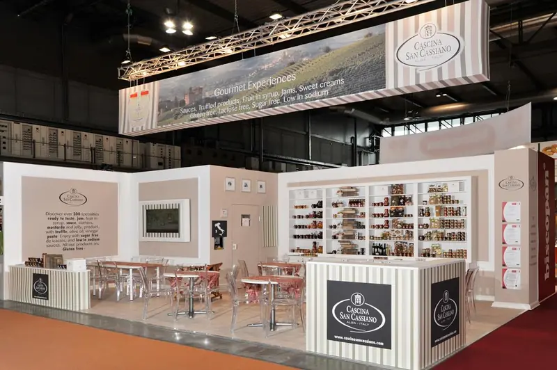 Stand con banco bianco, scaffali e grafica di paesaggio