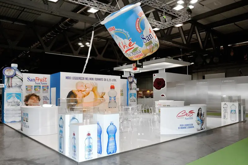 Stand con grande vasetto di yogurt sospeso e bottiglie d'acqua