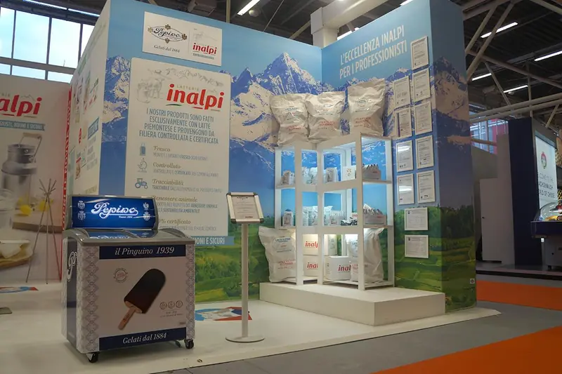 Stand Inalpi con grafica di montagne e frigorifero dei gelati