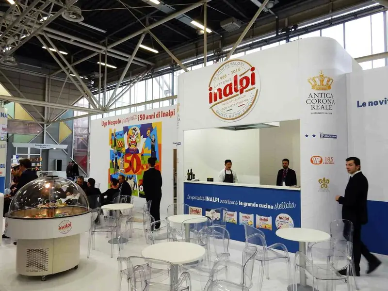 Stand Inalpi Antica Corona Reale con banco bianco e tavolini