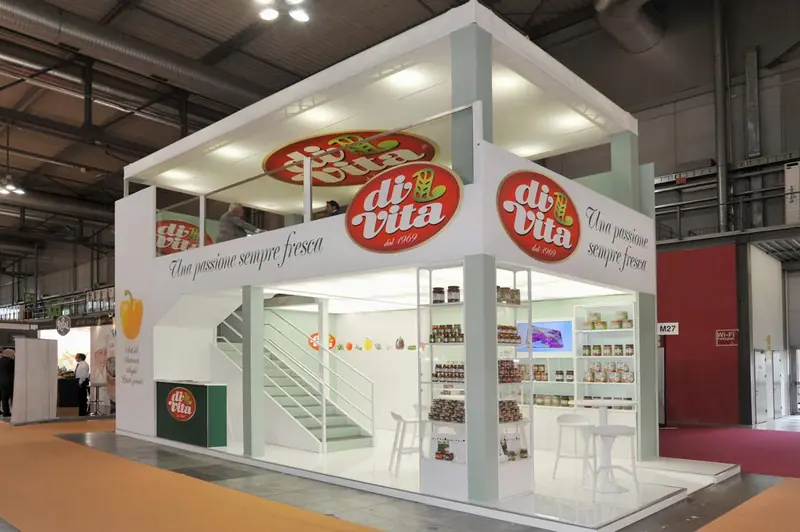 Stand bianco a due piani con scala e insegne rosse