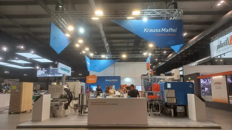 Stand Krauss Maffei con insegne blu sospese
