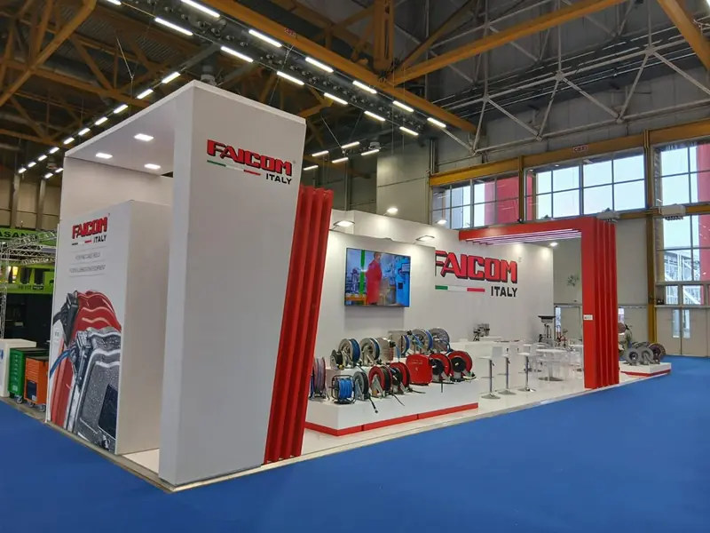 Stand Faicom Italy con pannelli rossi e attrezzature esposte