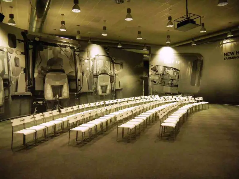 Sala con sedie bianche in fila in un capannone
