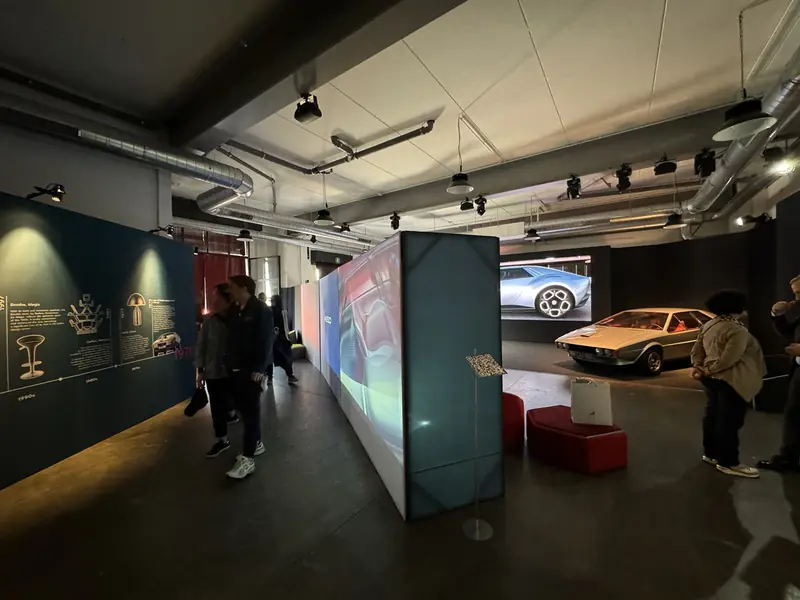 Mostra sull'automobile con pareti scure, schermi e due auto d'epoca