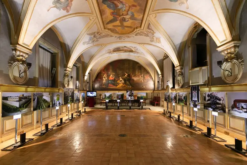 Sala affrescata con fotografie esposte su supporti lungo le pareti