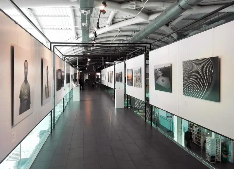Corridoio con pannelli bianchi e fotografie in una galleria