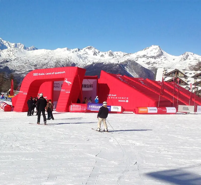 Strutture rosse gonfiabili sulla neve con montagne sullo sfondo