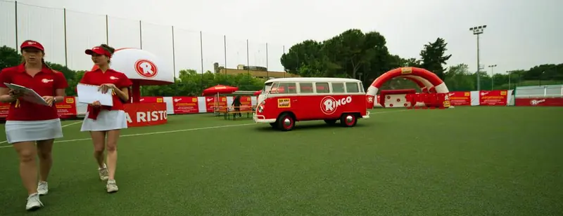 Furgone retrò rosso e ragazze su un campo da calcio in erba