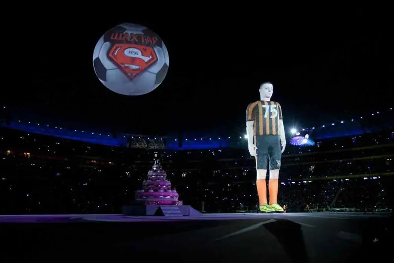 Calciatore gonfiabile gigante con pallone luminoso, di notte