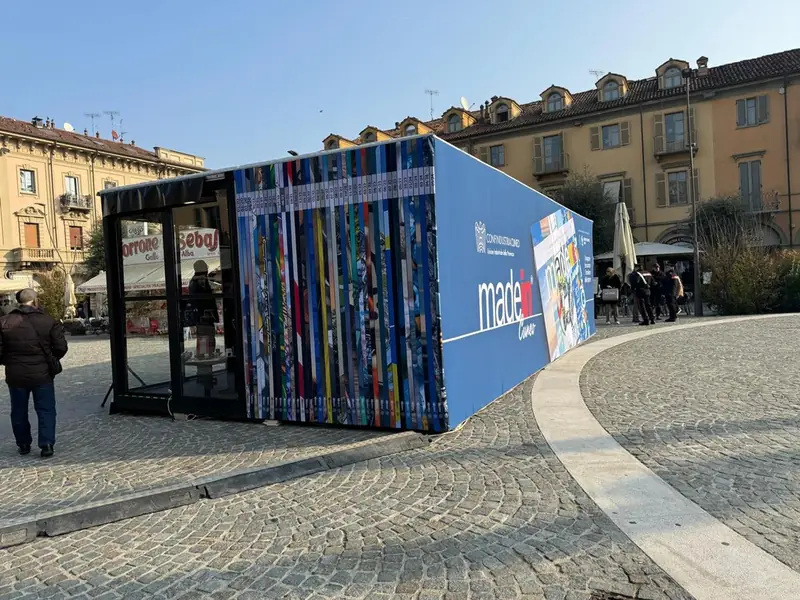Padiglione temporaneo con parete laterale colorata "made in Cuneo" in una piazza