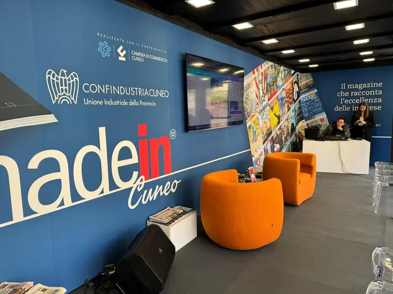 Interno dello stand Made in Cuneo con parete blu e poltrone arancioni