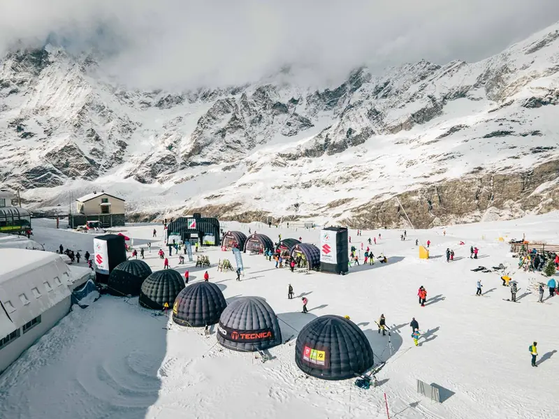 Cupole nere sulla neve davanti a un ghiacciaio