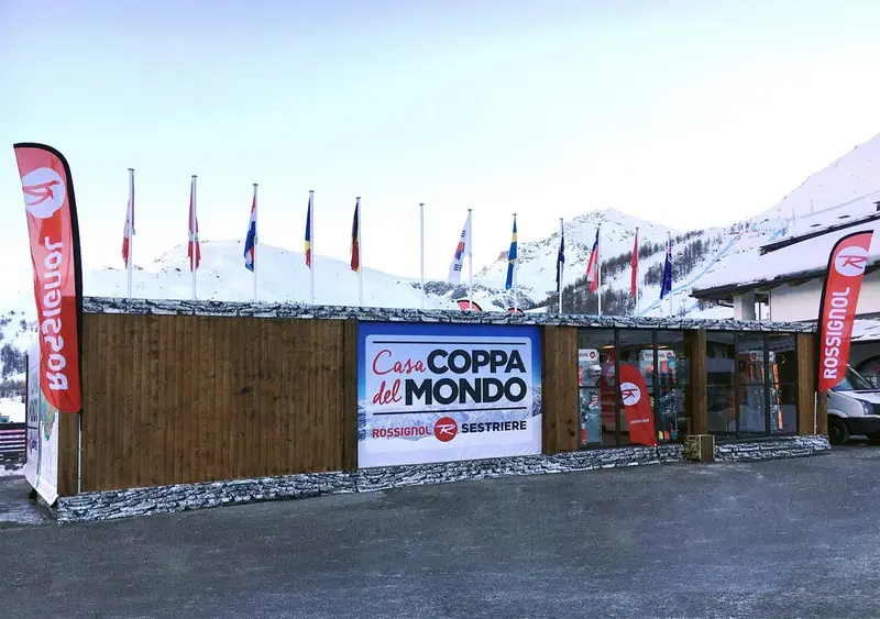 Casa Coppa del Mondo con facciata in legno e bandiere in montagna