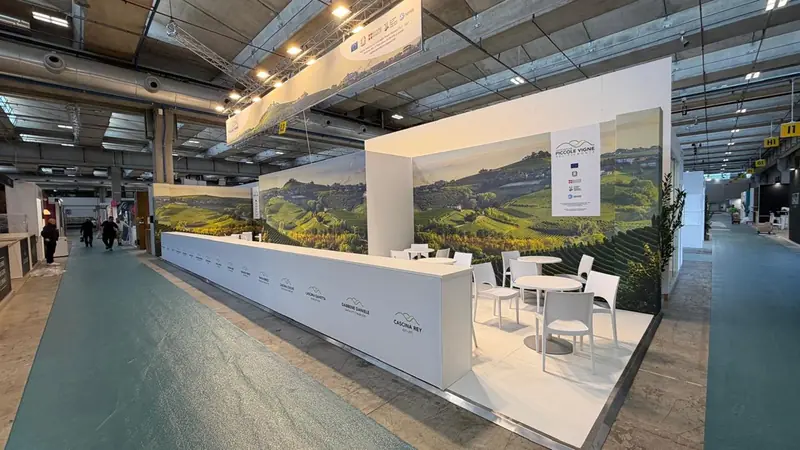 Lungo banco bianco con parete grafica di colline vitate in una fiera