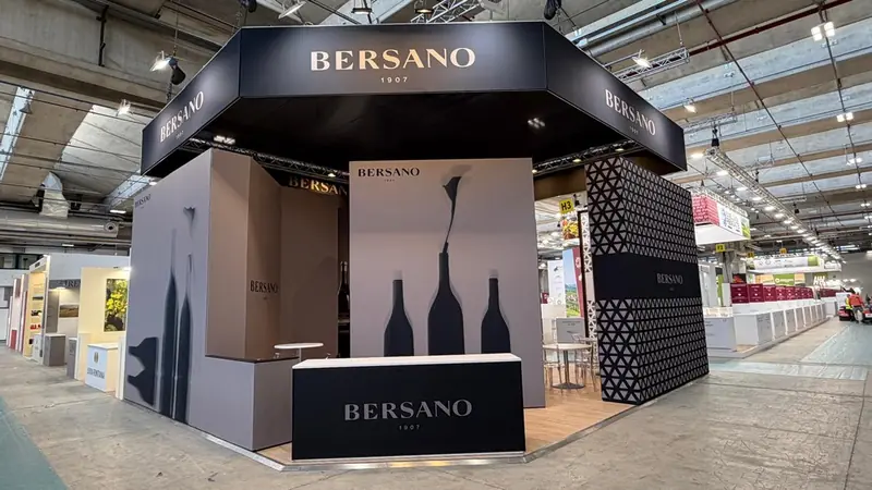 Stand Bersano con insegna nera, sagome di bottiglie e pannelli