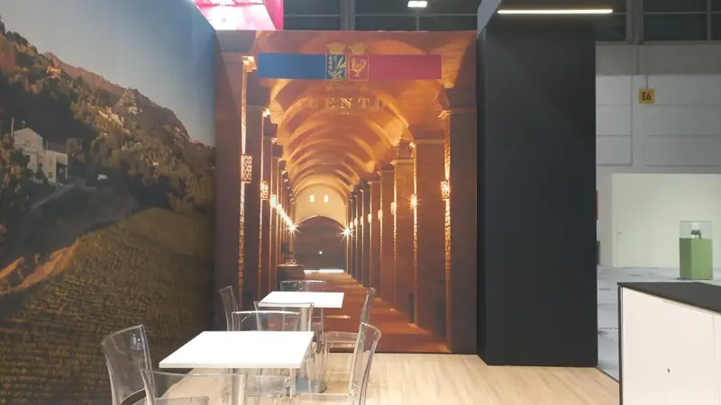 Parete grafica con cantina di botti e tavolini in uno stand