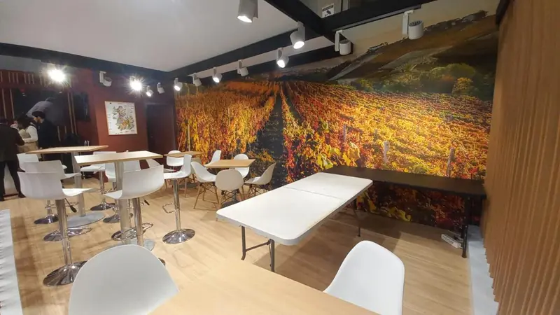 Area tavoli con parete grafica di vigneti autunnali