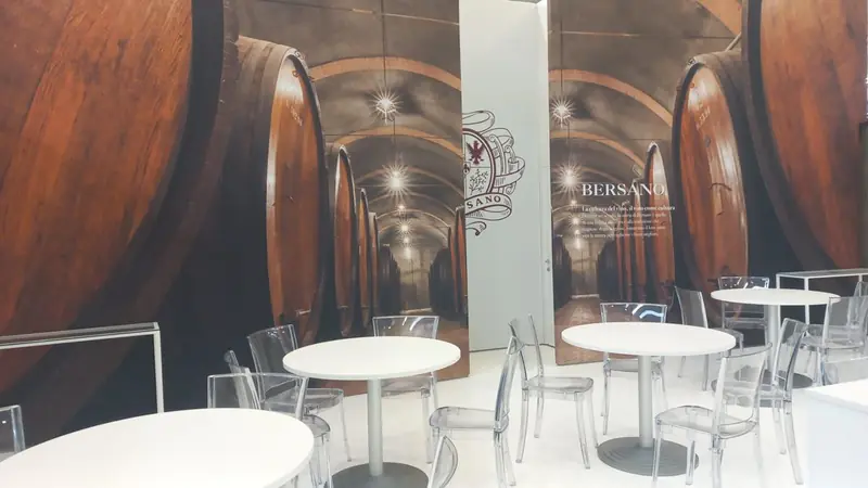 Grafica di botti in cantina con tavolini rotondi bianchi
